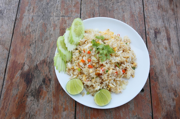 Premium Photo | Fried rice in a white plate on an old brown wooden table.