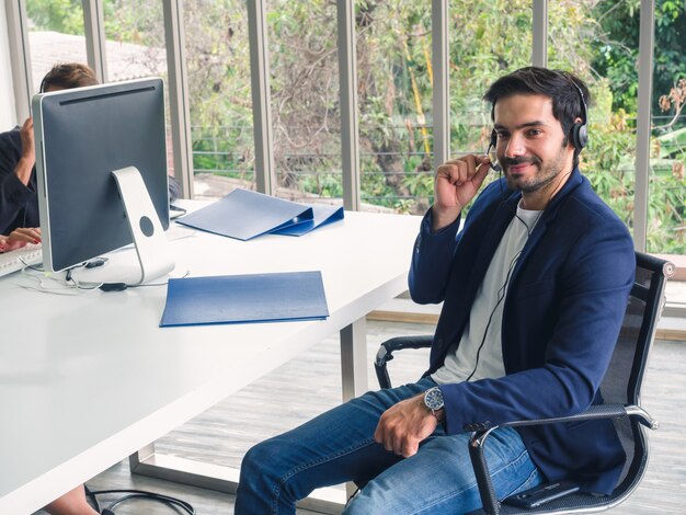 Friendly Operator Man Agent With Headsets Working In A Call Centre