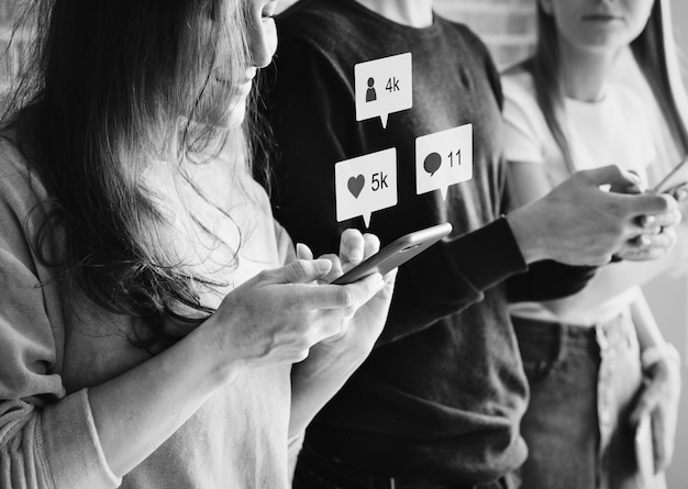 Friends using smartphones together outdoors Free Photo