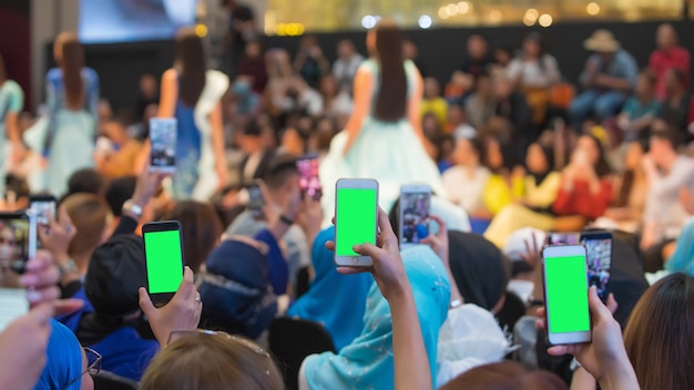 Front row vip guests people from audience filming vdo fashion show with mobile smart phone Premium Photo