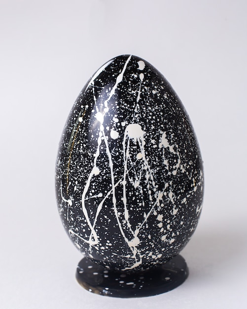 Download Free Photo | Front view black chocolate egg in white speckled on stand