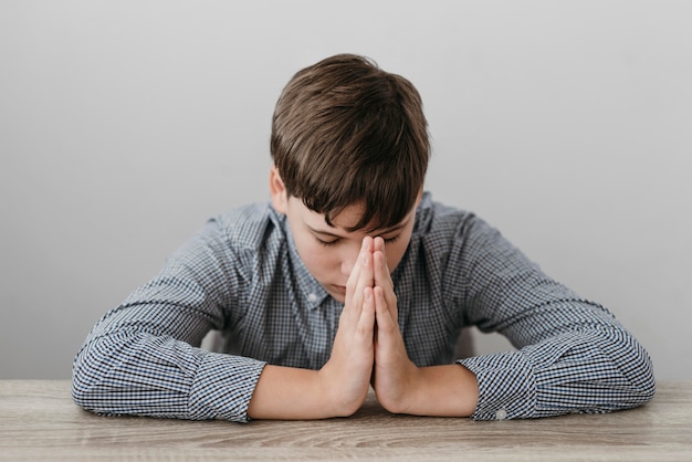 Free Photo | Front view boy praying at the table