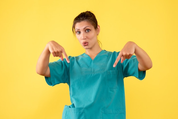 Free Photo | Front view female doctor in medical shirt on yellow background