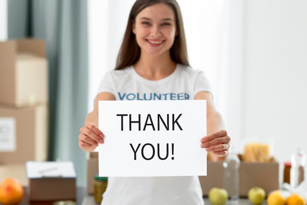 Front view of female volunteer thanking you for helping with food donations Free Photo