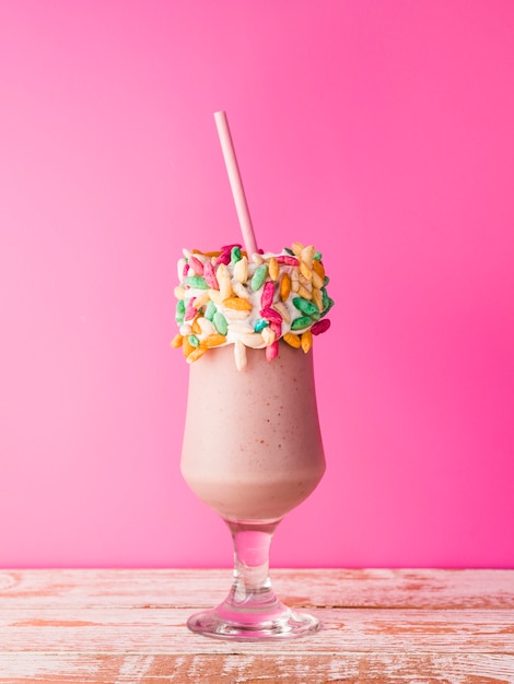 Free Photo | Front view of a glass of milkshake with pink background