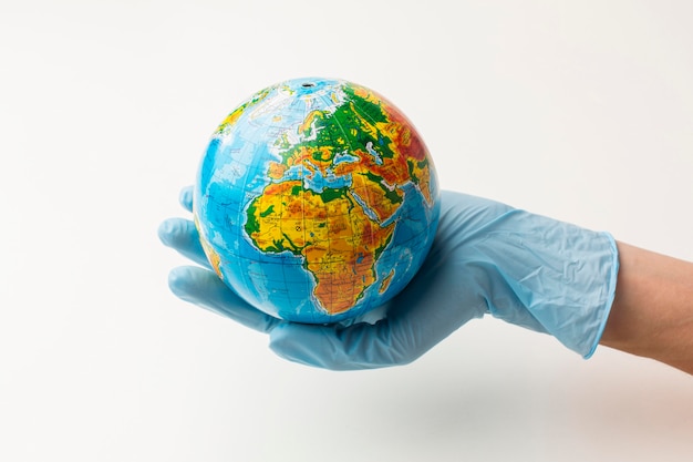 Premium Photo | Front view of hand with gloves holding earth globe