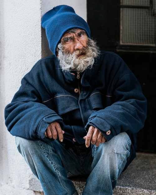 Free Photo | Front view of homeless man with beard on doorstep