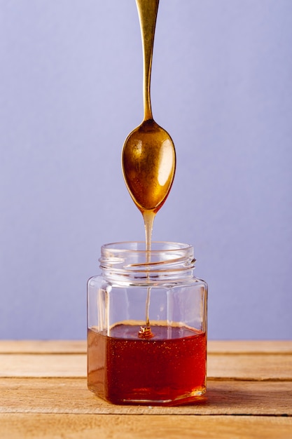 Download Premium Photo Front View Honey Dripping Off Spoon In Jar Yellowimages Mockups