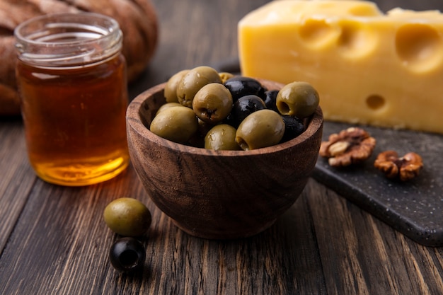 Download Free Photo Front View Honey In A Jar With Maasdam Cheese On A Stand And Olives On The Table