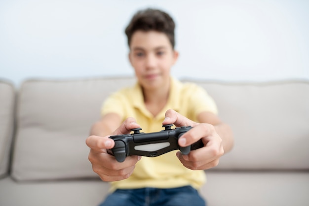 Free Photo Front View Kid With Controller On The Couch