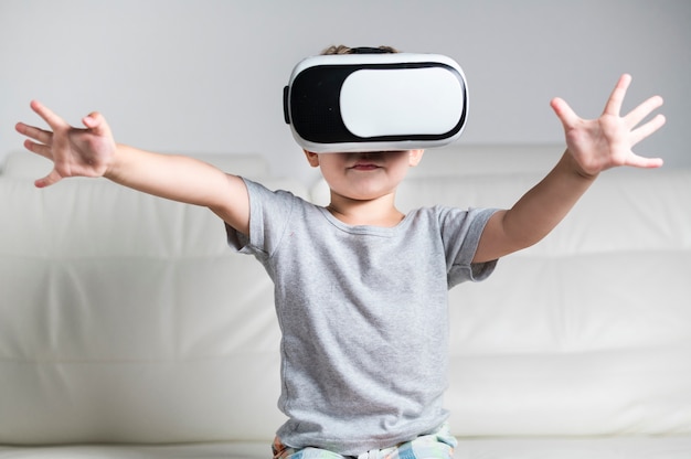 Free Photo | Front view little boy enjoying a pair of vr headset