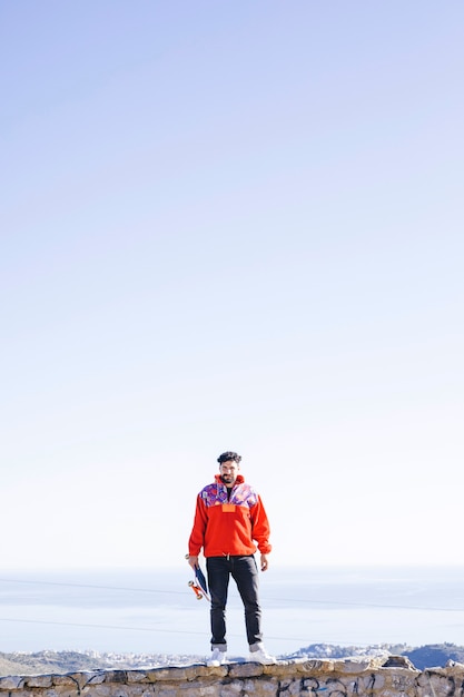 Front view of man standing on stone wall Free Photo