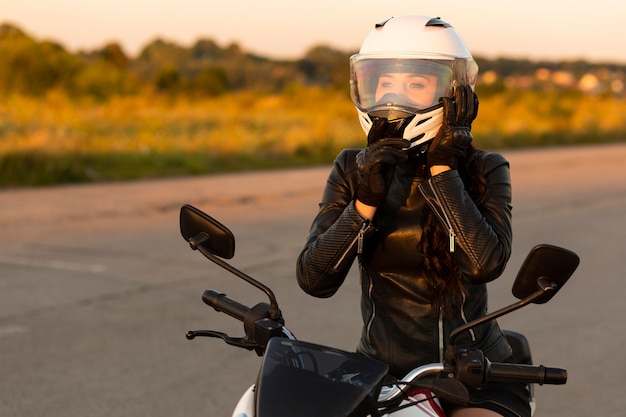 ヘルメットをかぶった女性バイクライダーの正面図 プレミアム写真