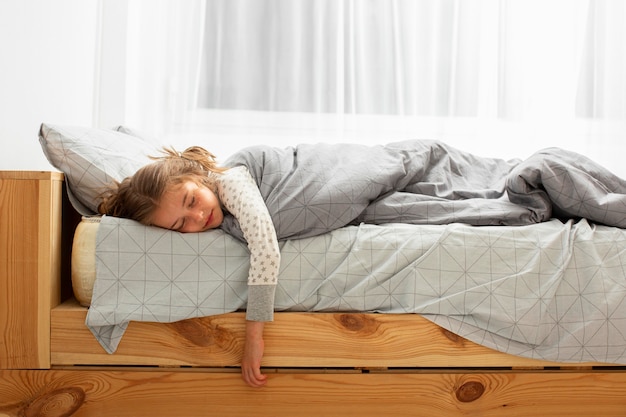 ベッドで寝ている女の子の正面図 プレミアム写真