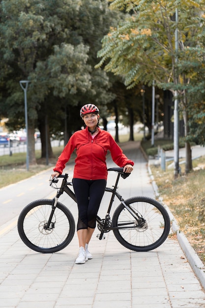 年配の女性が自転車で屋外でポーズの正面図 無料の写真