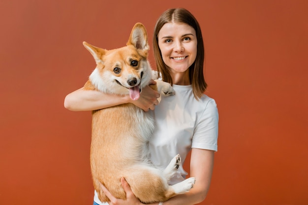 かわいい犬と一緒にポーズ笑顔の女性の正面図 無料の写真