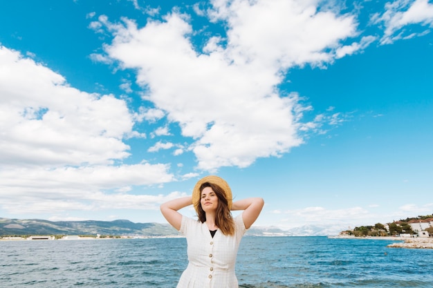 空の雲と海でポーズの女性の正面図 無料の写真