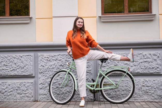 屋外で自転車で馬鹿げたポーズをとる女性の正面図 プレミアム写真