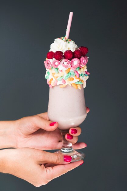 Free Photo | Front view oh hands holding glass of milkshake