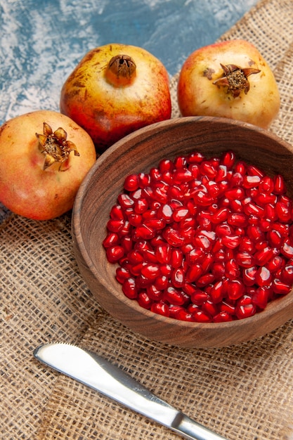 Free Photo Front View Pomegranate Seeds In Wooden Bowl Dinner Knife