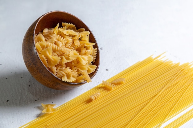 Free Photo | A front view raw italian pasta long and little pasta bowl