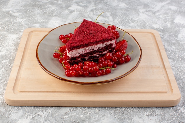 正面の赤いケーキスライスフルーツケーキピースプレートの内側に新鮮なクランベリーとイチゴの木製デスクティー 無料の写真