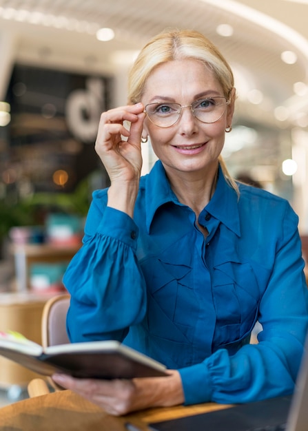 Free Photo Front View Of Smart Older Business Woman With Glasses Holding Agenda