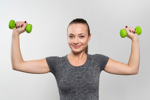 Free Photo | Front view of smiley woman with physiotherapy weights