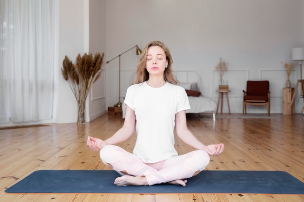 Front view of woman doing yoga at home | Free Photo