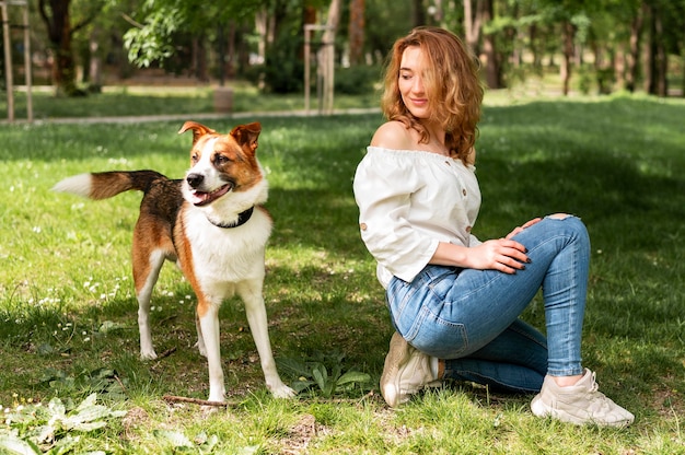 犬と公園で散歩を楽しむ正面女性 無料の写真