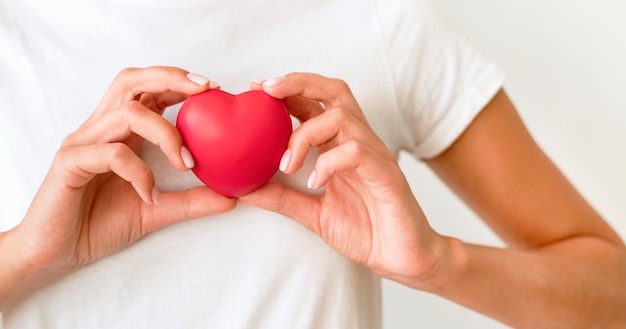 Front view of woman holding heart shape Free Photo
