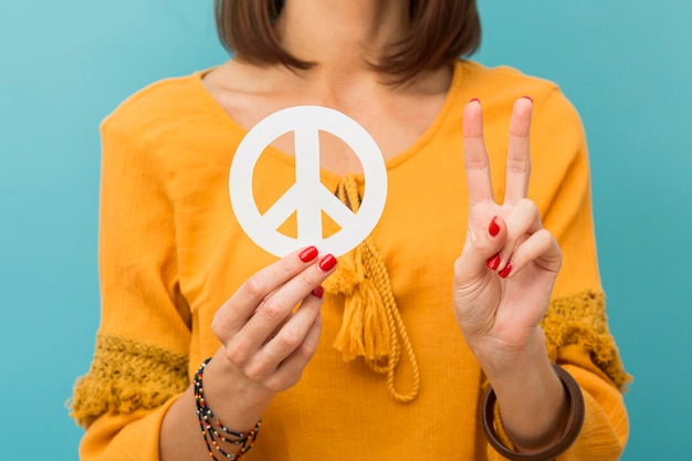 Front View Woman Holding And Making Peace Sign Free Photo