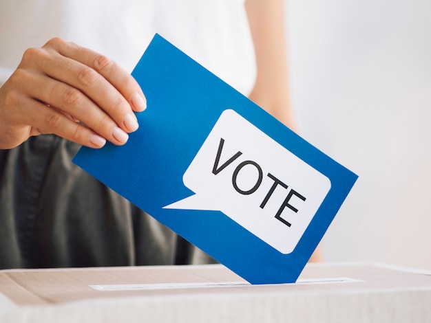 Front view woman putting a voting message in a box close-up Free Photo