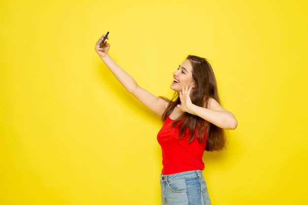 Free Photo A Front View Young Beautiful Lady In Red Shirt And Blue Jeans Taking A Selfie Model Girl Color Female