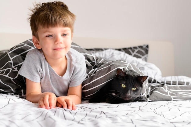 Premium Photo | Front view young boy with his cat at home