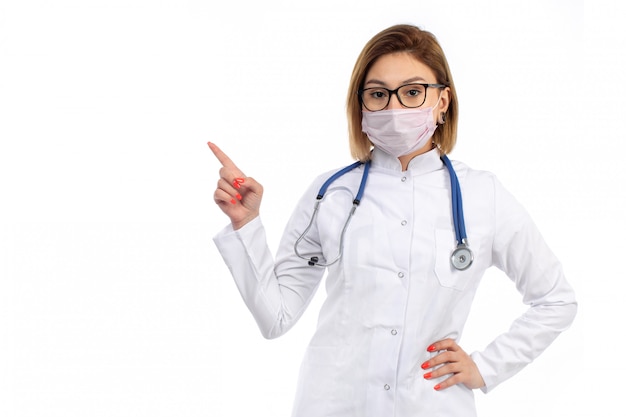 Free Photo | A front view young female doctor in white medical suit with stethoscope wearing white protective mask on the white