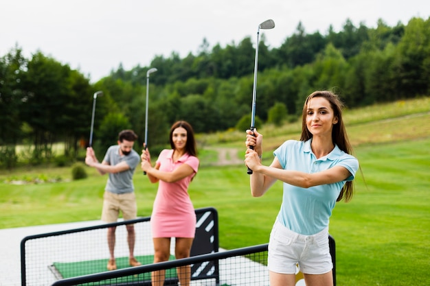 Front view of young golfers with stick up Free Photo