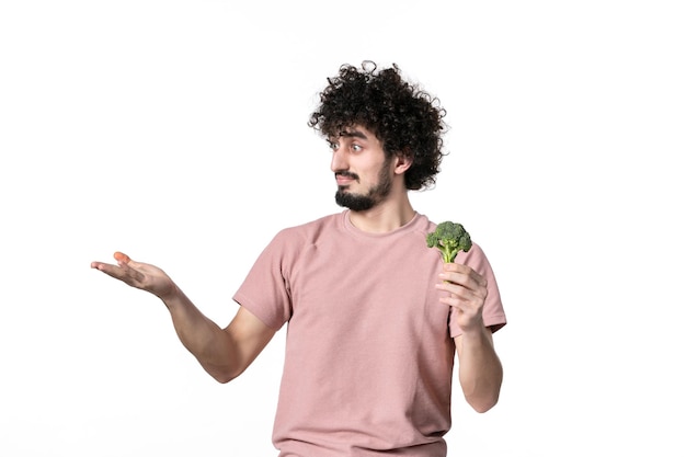 Front view young male holding little green broccoli on white background body horizontal vegetable human diet health salad weight Free Photo