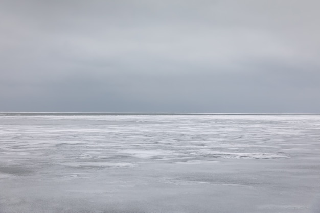 Premium Photo | Frozen sea water and gray sky over horizon