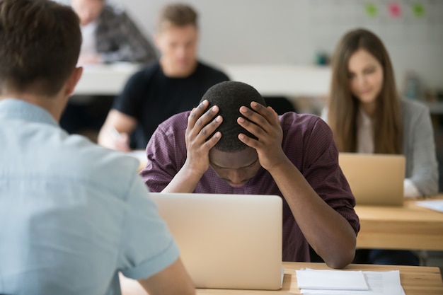 frustrated african office worker having problem holding head hands 1163 3935