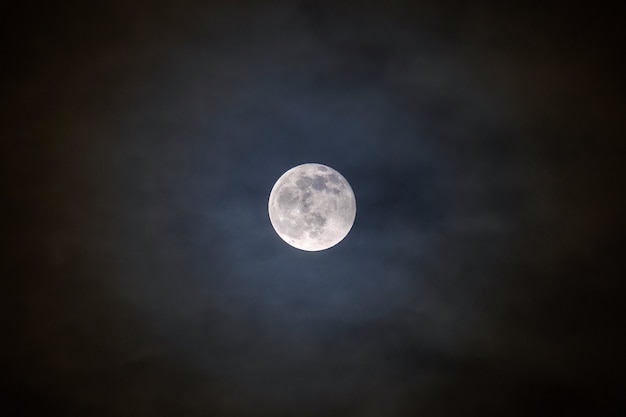 Premium Photo | Full bright moon with illuminated clouds in front of it.