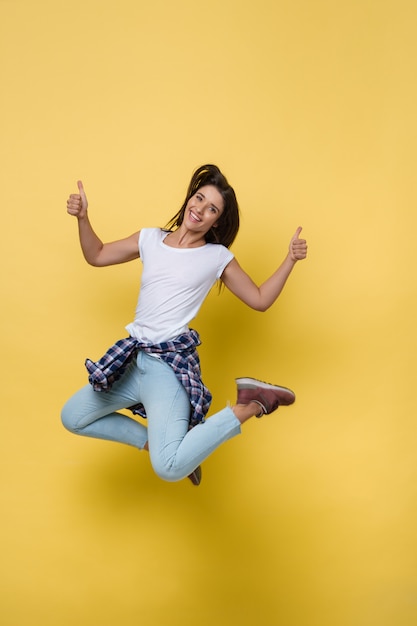 Full length portrait of a cheerful casual caucasian woman jumping  Premium Photo