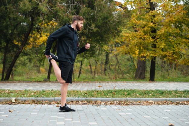 Premium Photo | Full length runner warming up in park