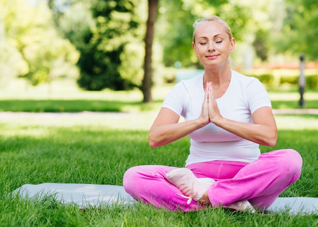 Free Photo | Full shot happy woman meditating outdoors