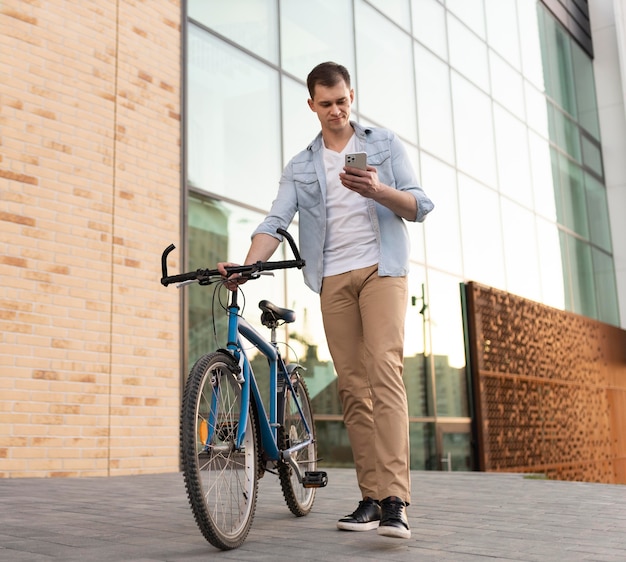 Free Photo | Full shot man holding smartphone