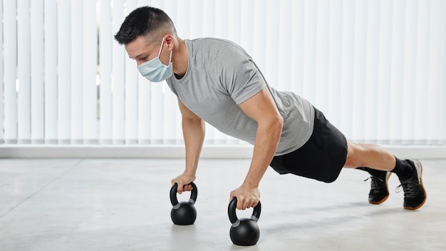 Full shot man working out with mask Free Photo