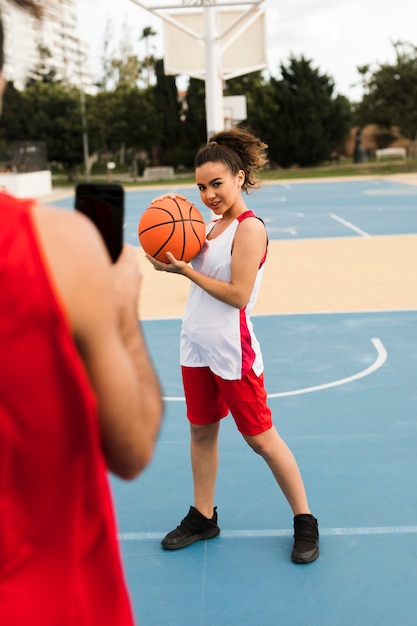 バスケボールでポーズの女の子の完全なショット 無料の写真