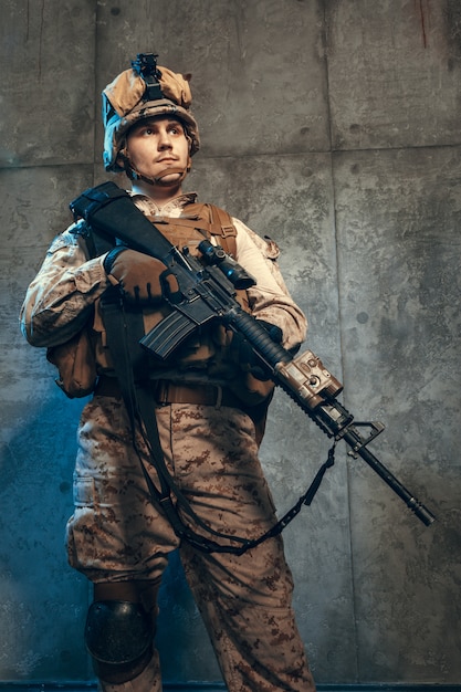 ピストルとアサルトサービスライフルで武装した 迷彩服とヘルメットの完全装備の軍隊兵士 プレミアム写真