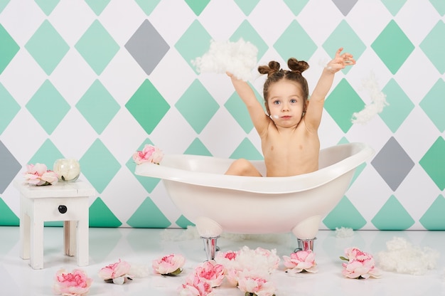 おかしい 赤ちゃん 白人 女の子 水浴 遊び 水 おもちゃ 花 遊び プレミアム写真