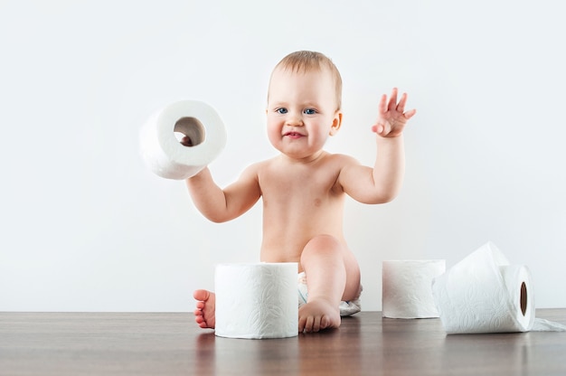 Premium Photo | Funny baby and toilet paper on white wall. toddler